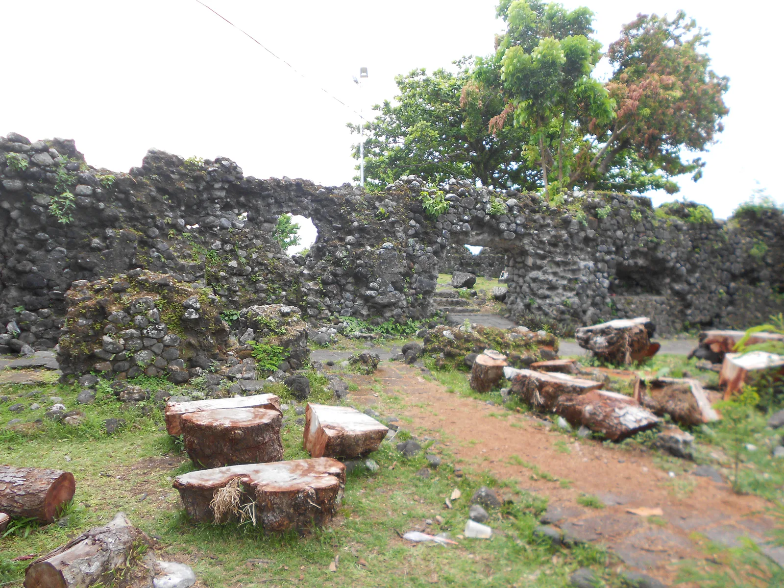 Low stone remains and tropical greenery at Cagsawa