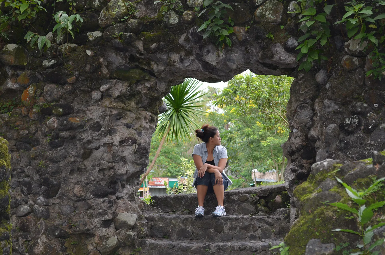A visitor seen through a stone window in the Cagsawa ruins
